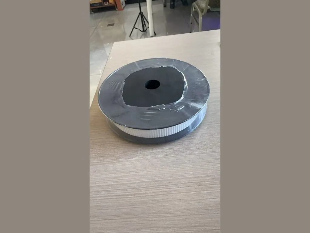 Băng graphite: Cuộn băng graphite đặt trên mặt bàn, lõi tròn lớn