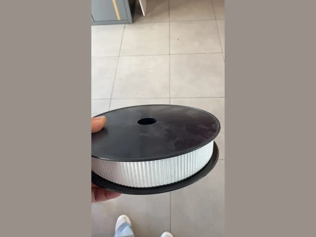 Băng graphite: Cuộn băng graphite viền trắng đặt trên tay nâng đỡ