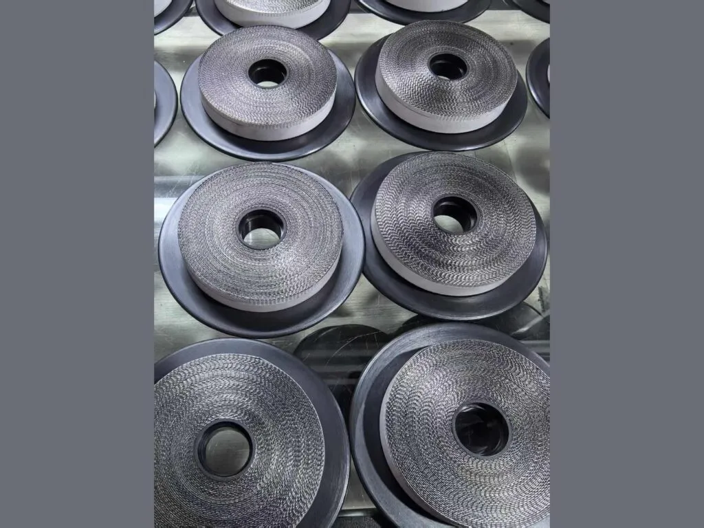 Băng graphite: Nhiều cuộn băng graphite xếp trên bàn thép nhìn từ trên