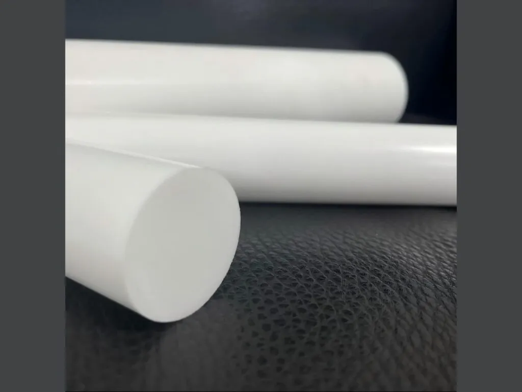 Cây nhựa teflon PTFE: Ba cây nhựa teflon PTFE trắng đặc nằm trên nền da đen, cận mặt cắt