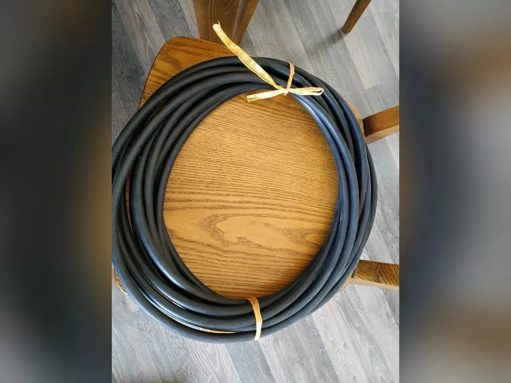 Dây silicon tròn đặc: Cuộn dây silicon đen buộc dây vàng trên ghế gỗ