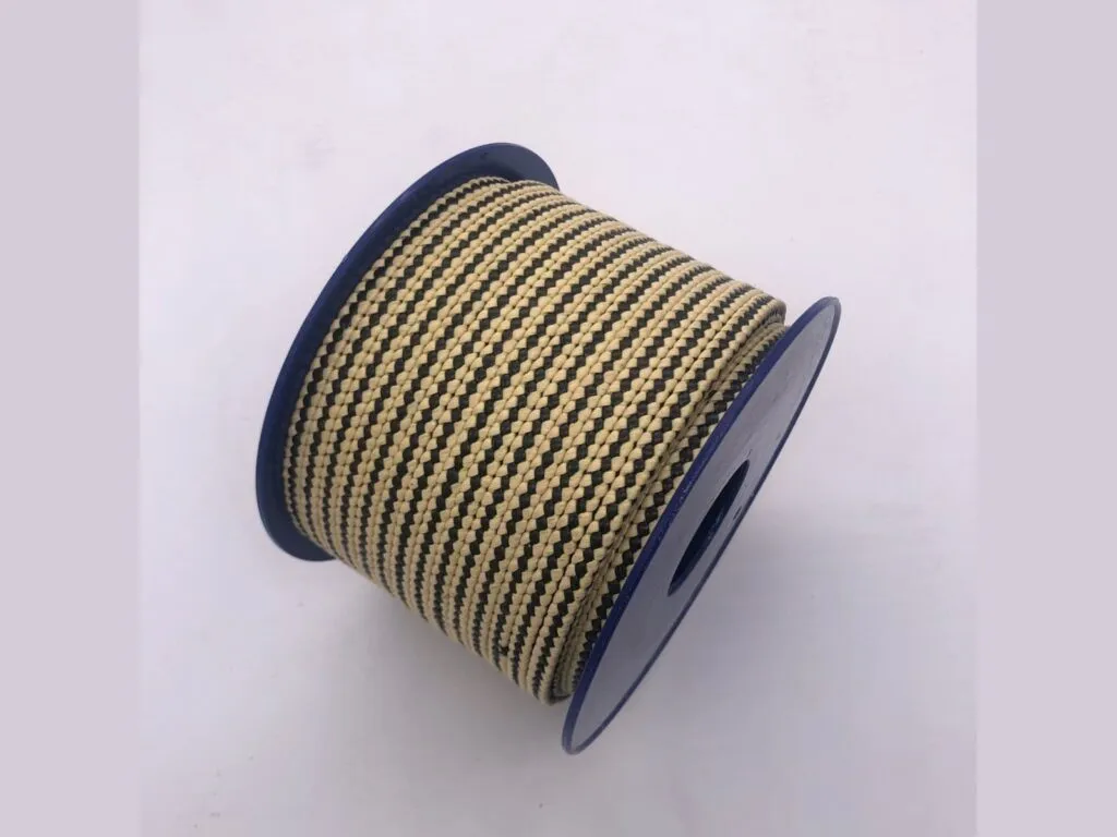 Dây tết chèn aramid: Cuộn dây tết chèn aramid sợi vàng đen đặt trên lõi nhựa xanh