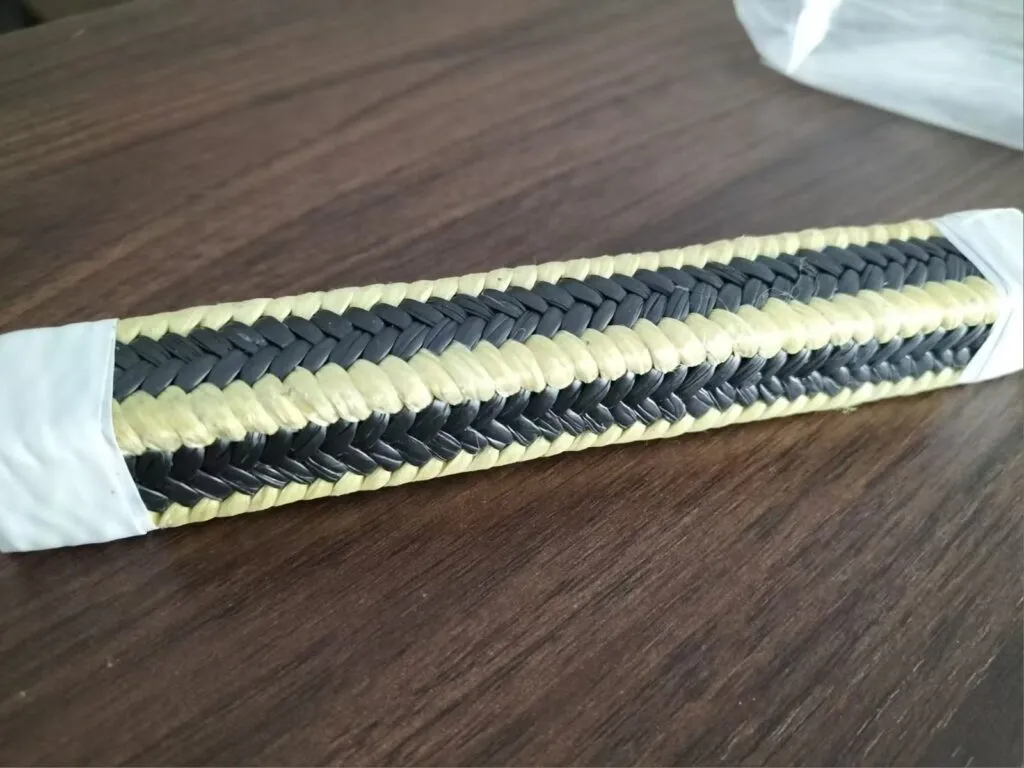 Dây tết chèn aramid: Đoạn dây tết chèn aramid viền vàng lõi sợi đen trên bàn