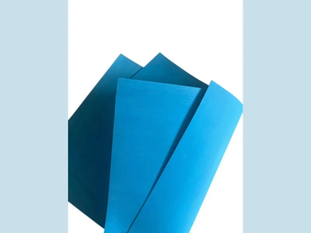 Gioăng không amiang sợi aramid: Hai tấm gioăng xanh dương gấp nhẹ trên nền trắng