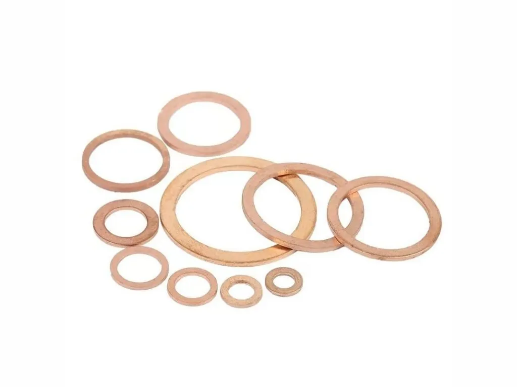 Gioăng kim loại đặc: Bộ vòng đệm đồng đỏ nhiều kích thước rải trên nền trắng