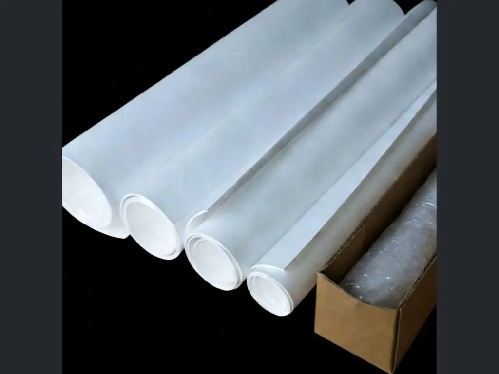 Gioăng PTFE biến tính: Bốn cuộn tấm PTFE trắng đặt cạnh hộp giấy