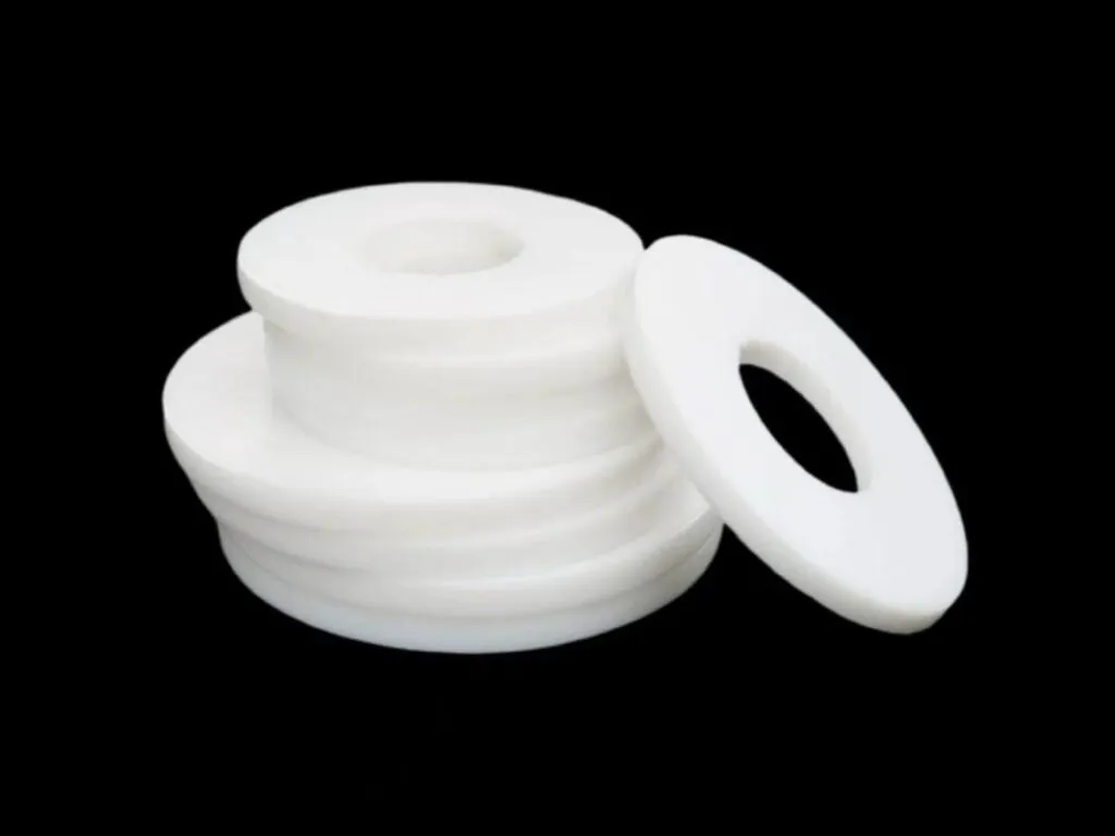 Gioăng PTFE mặt bích: Chồng gioăng PTFE trắng dày và một vòng đặt nghiêng cạnh bên