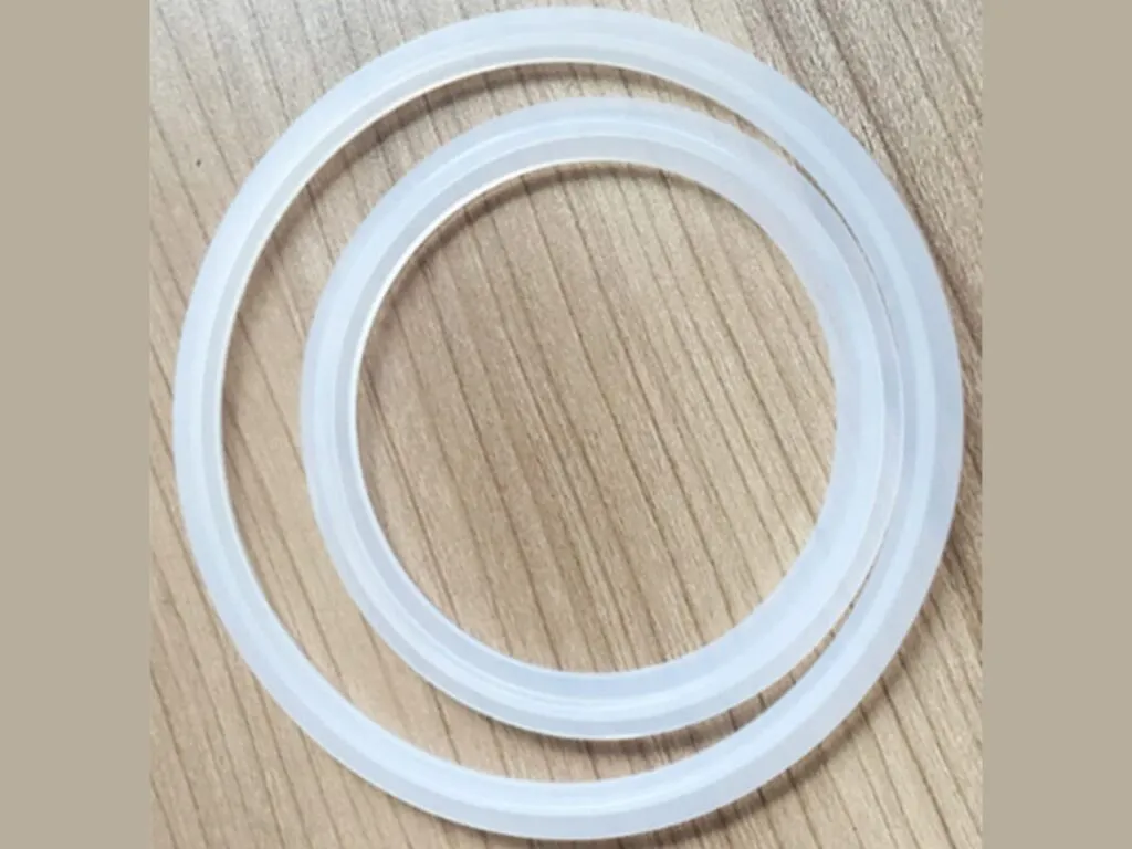 Gioăng tri clamp: Hai gioăng tri clamp silicone trong mờ đặt trên mặt gỗ