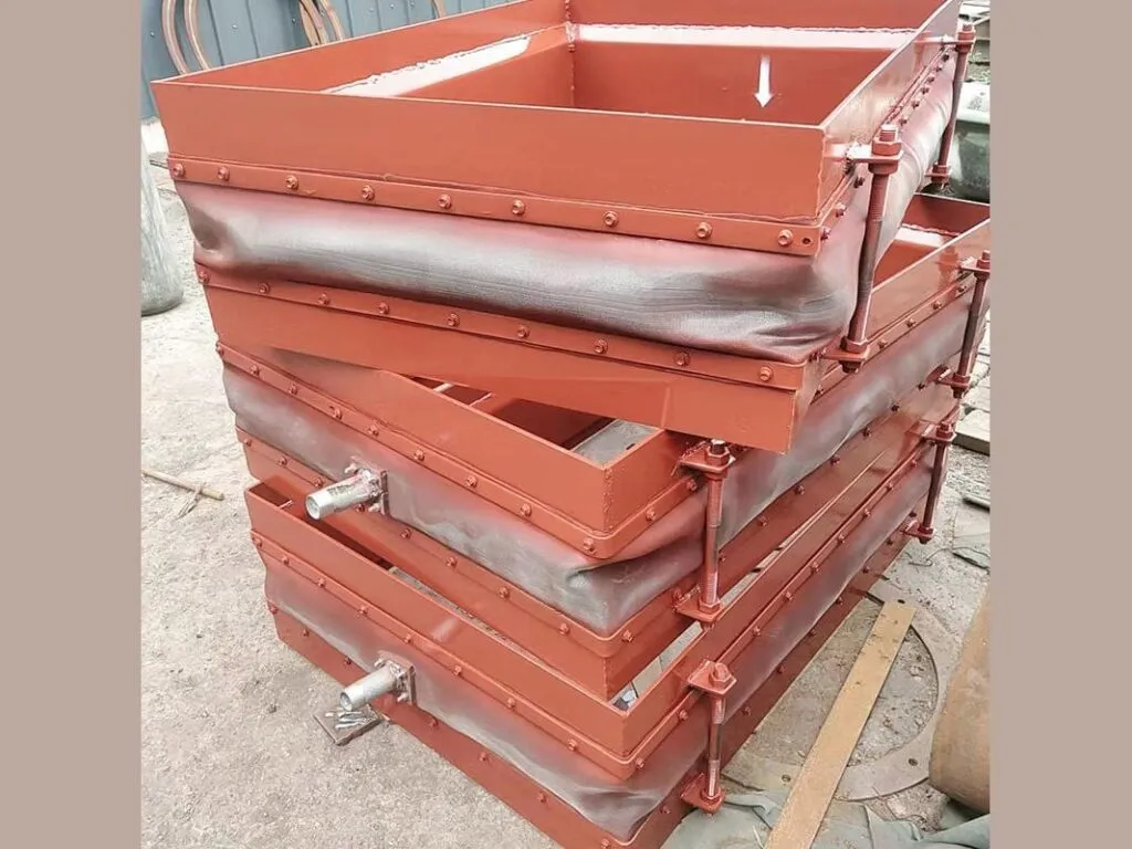Khớp giãn nở chữ nhật: Ba khớp giãn nở chữ nhật khung đỏ xếp chồng ngoài xưởng