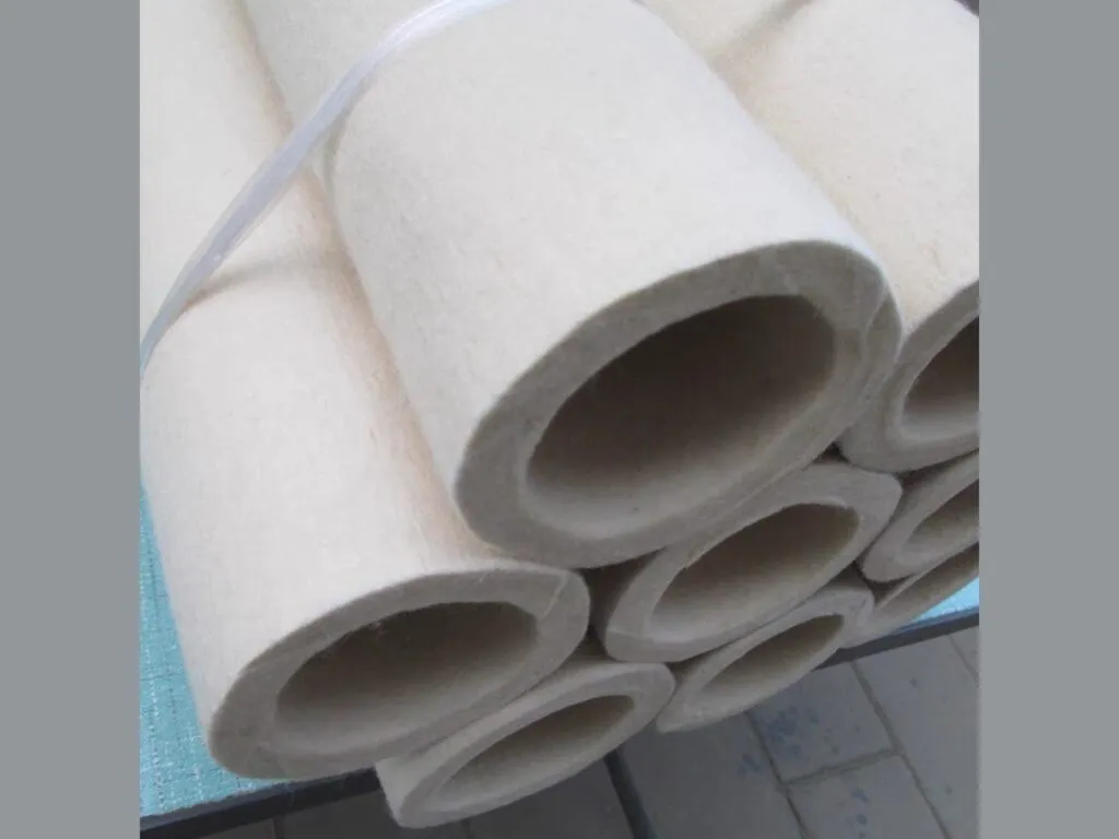 Nỉ bọc trục chịu nhiệt: Các ống nỉ trắng dày chồng nhau, nhìn thẳng vào lòng ống
