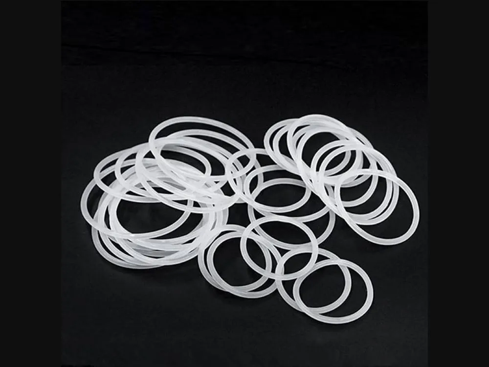 Oring silicone: Rất nhiều oring silicone trắng mảnh chồng lên nhau trên nền đen