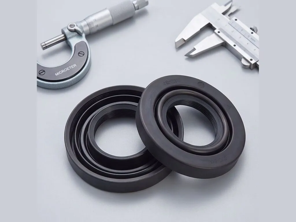 Phớt chắn dầu TC NBR: Hai phớt chắn dầu NBR đen đặt cạnh panme và thước cặp
