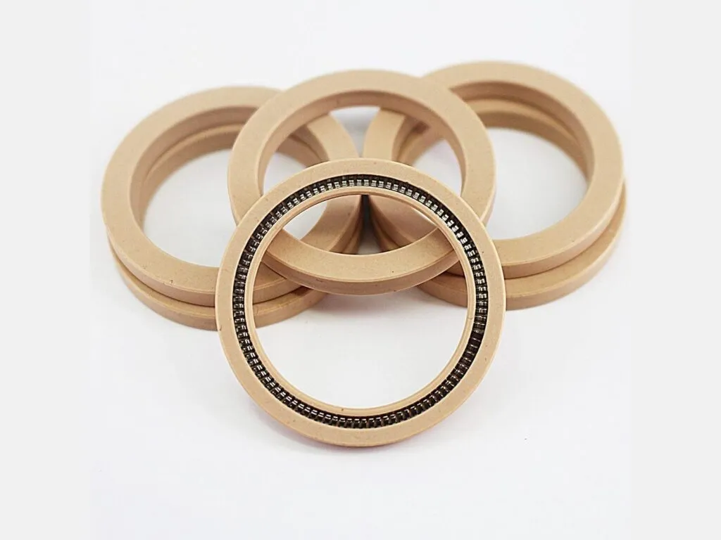Phớt PTFE: Bốn phớt lò xo màu be xếp lệch nhìn từ trên