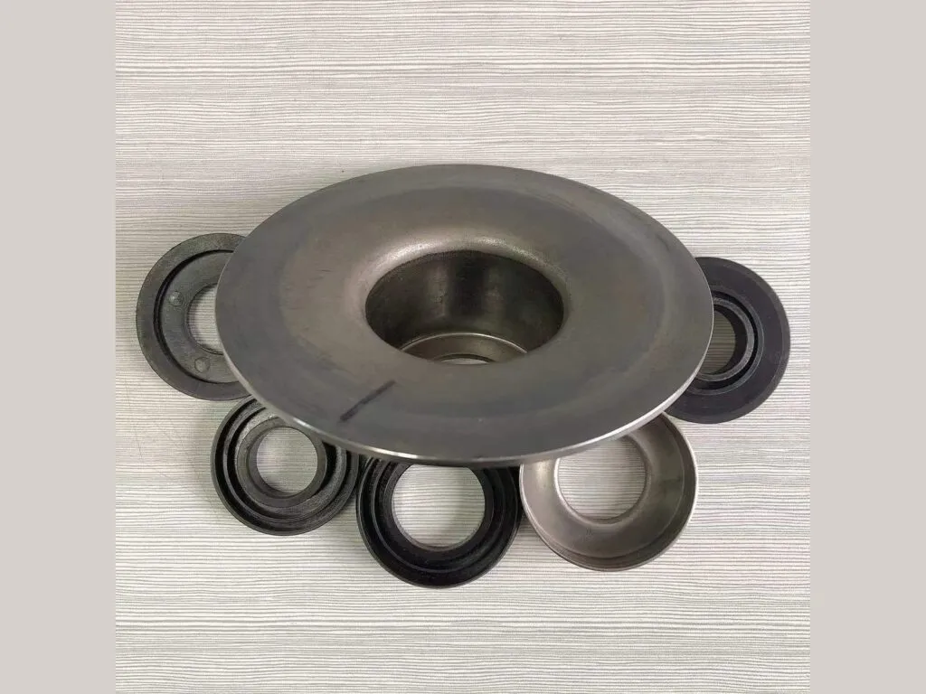 Phớt trục con lăn băng tải: Chén thép lớn vây quanh các phớt đen và vỏ thép nhỏ