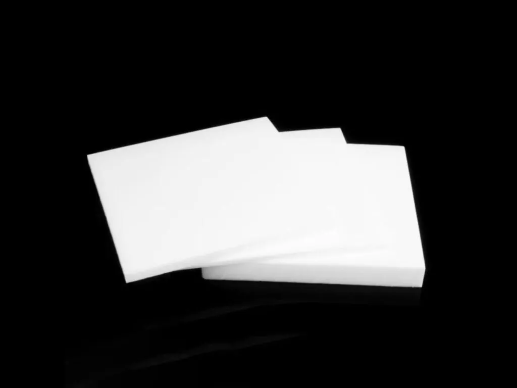 Tấm teflon PTFE: Ba tấm teflon trắng mỏng xếp chéo trên nền đen