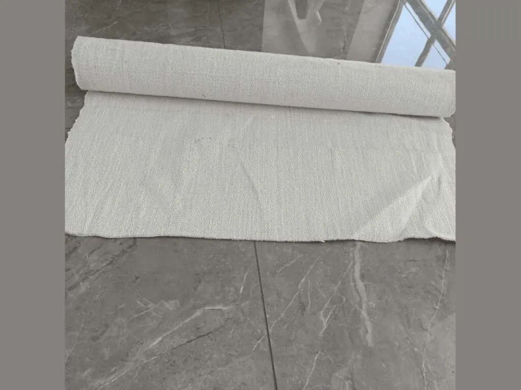 Vải ceramic chịu nhiệt: Cuộn vải ceramic trải dài trên nền gạch xám trong nhà xưởng sáng