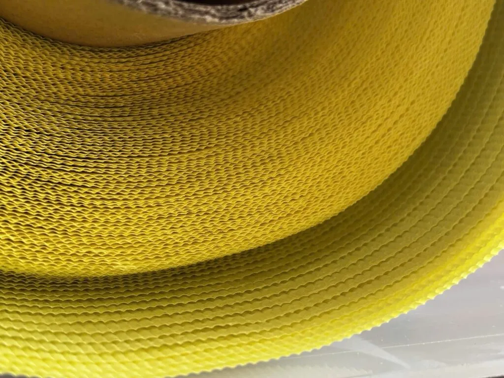 Vải teflon: Cuộn vải teflon có keo nhìn từ mặt giấy lót vàng