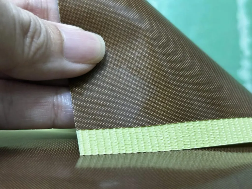 Vải teflon: Mặt vải teflon nâu bóng lật mép thấy lớp keo vàng