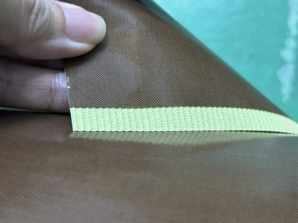Vải teflon: Tấm vải teflon nâu trải phẳng, mép lớp lót vàng