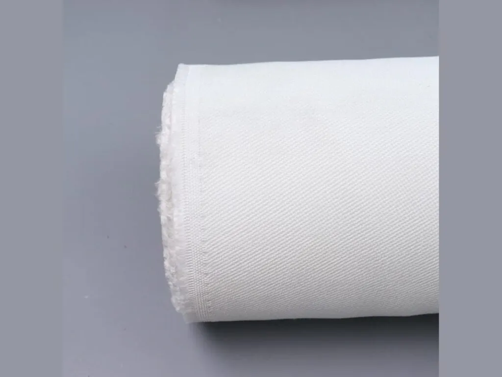 Vải thủy tinh chịu nhiệt: Cuộn vải thủy tinh trắng đặt nằm trên nền xám